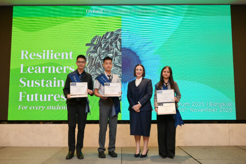 Three students on stage after being presented with their OxfordAQA Go Further Awards certificates